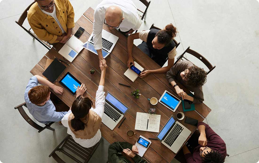 business meeting with two people shaking hands across the table